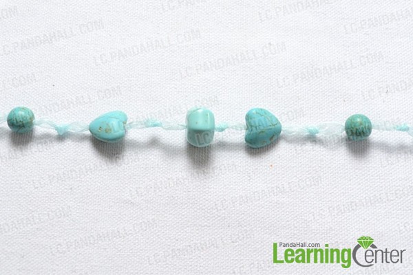 a strip of ribbon with turquoise beads and tying fast knot