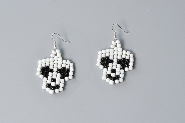 final look of the white and black seed bead stitch skull earrings