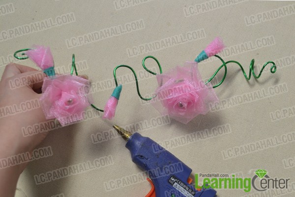 Add the two flowers and three buds to the aluminum wire with plastic gun 