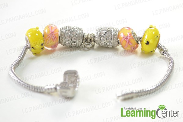 sliding the beads and Tibetan style hanger onto the bracelet